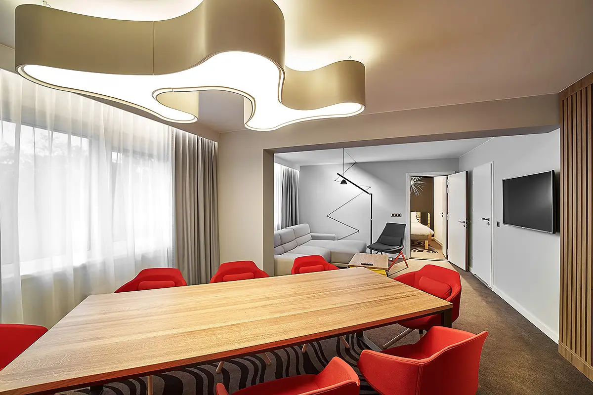 Jasny apartament hotelowy z designerskim oświetleniem – fotografia wnętrz