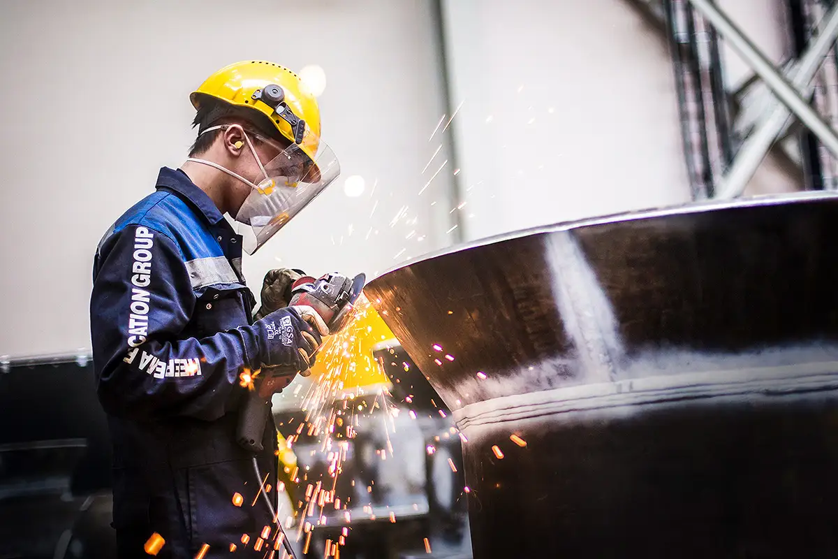 Pracownik w kasku ochronnym pracujący przy produkcji przemysłowej